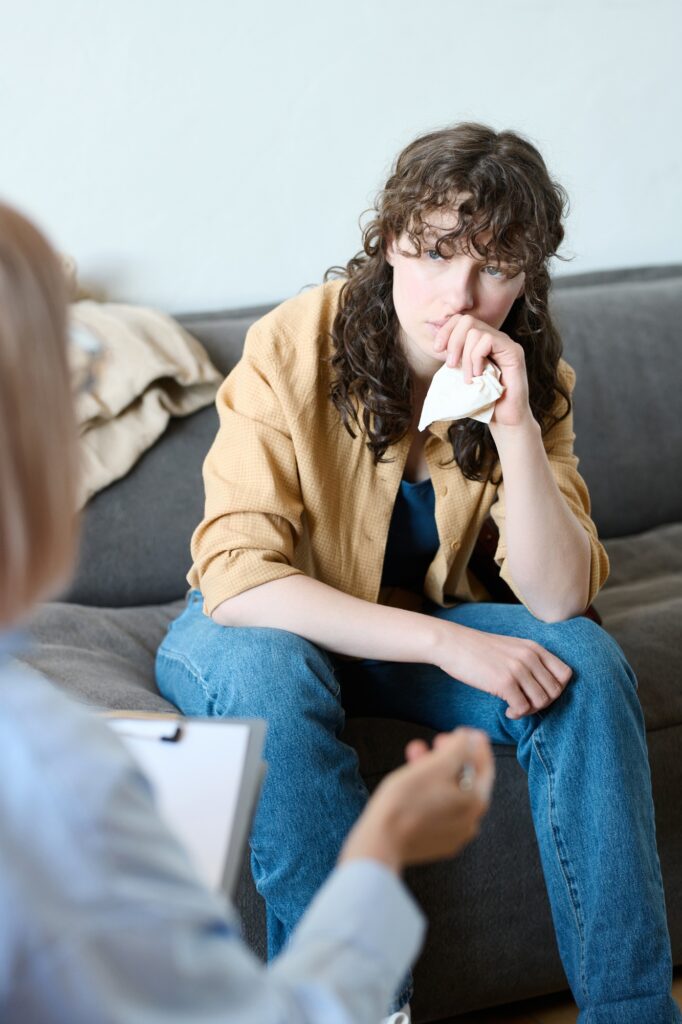 Young woman listening to advice of therapist